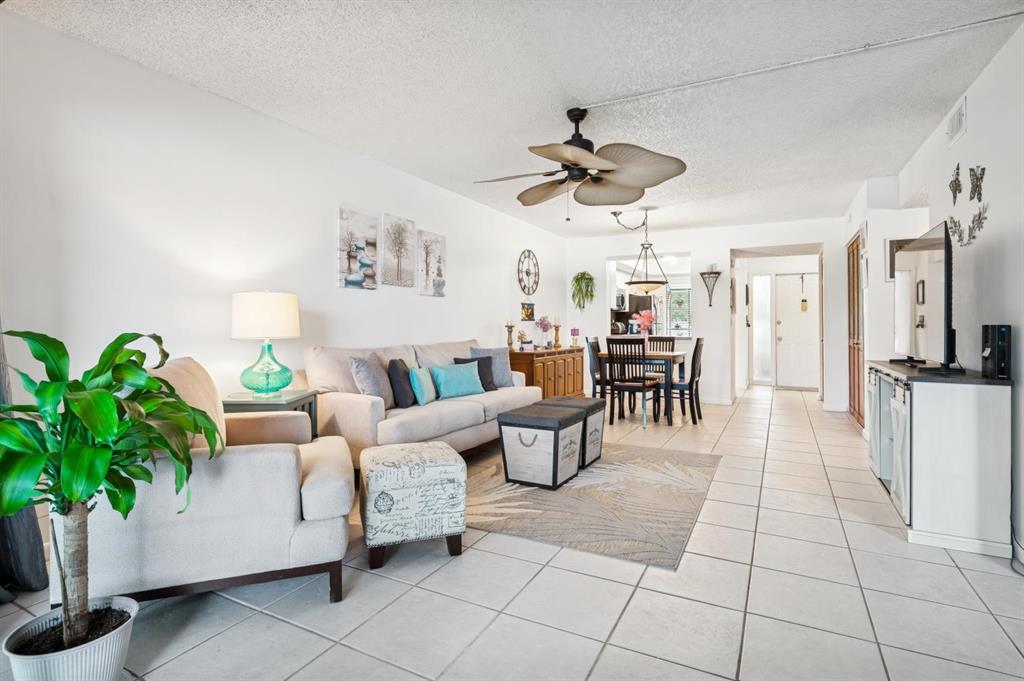 2249 Southwest 15th Street, Unit 185 Deerfield Beach, FL 33442 - Photo 3 of 31 a living room with patio furniture and a chandelier