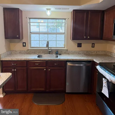 a kitchen with a sink cabinets and wooden floor