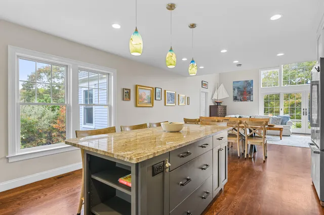 a large kitchen with stainless steel appliances granite countertop a stove a sink dishwasher and a refrigerator with wooden floor