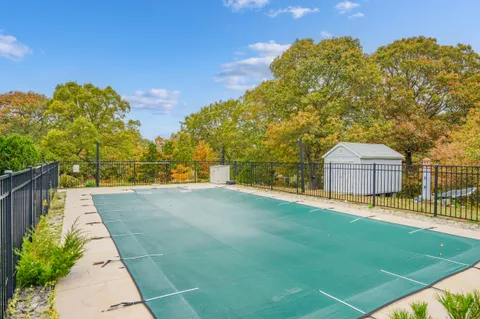 a view of a chair and table in backyard of the house