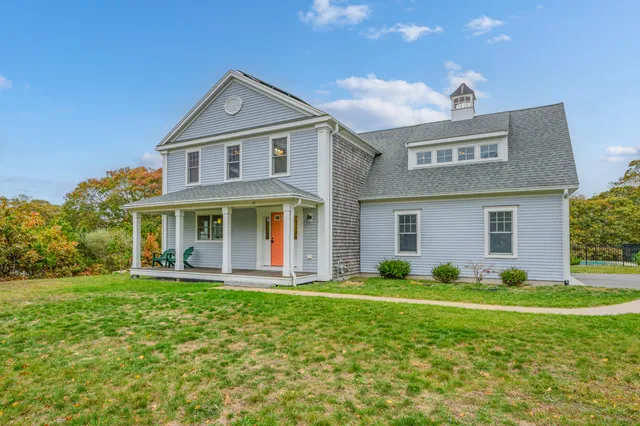 aerial view of a house with a big yard and large trees