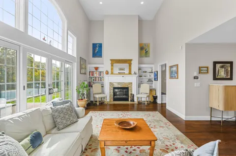 a living room with furniture and a dining table with wooden floor