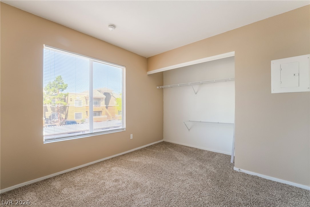 8070 West Russell Road, Unit 2024 Las Vegas, NV 89113 - Photo 14 of 19 A spacious bedroom featuring a large window, providing abundant natural light and an open closet for convenient storage.
