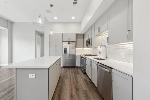 a kitchen with white cabinets appliances and sink