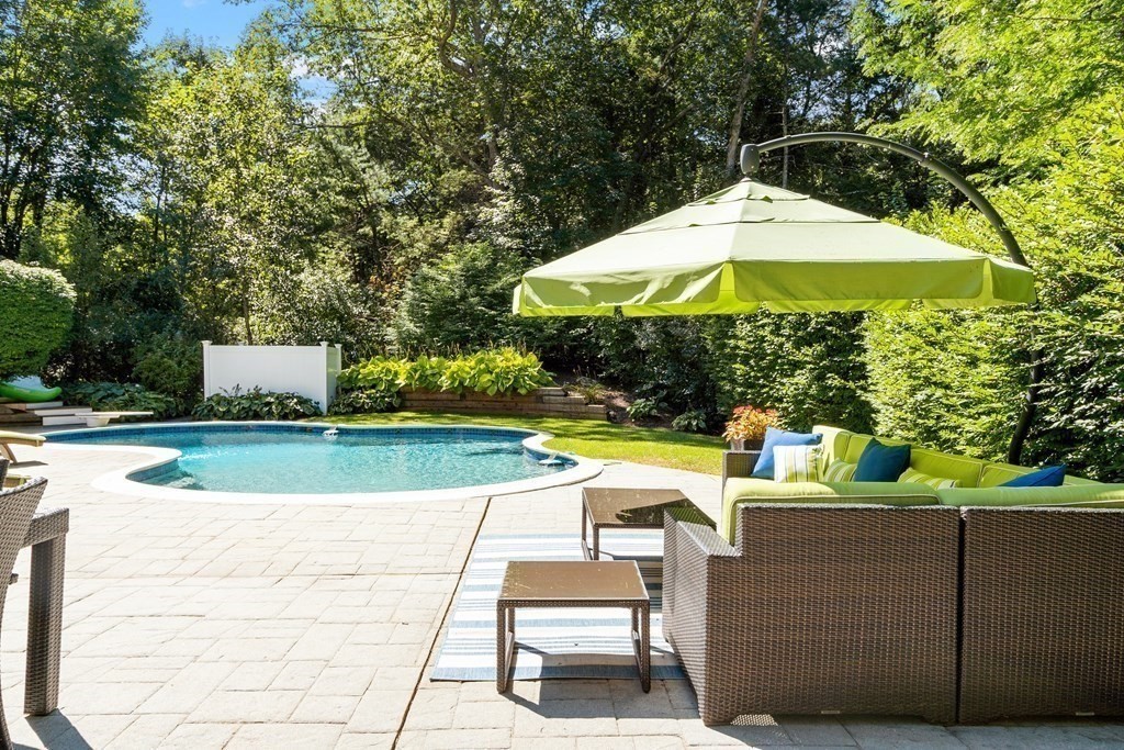 110 Mattison Drive Concord, MA 01742 - Photo 37 of 41 a view of a patio with a table and chairs under an umbrella