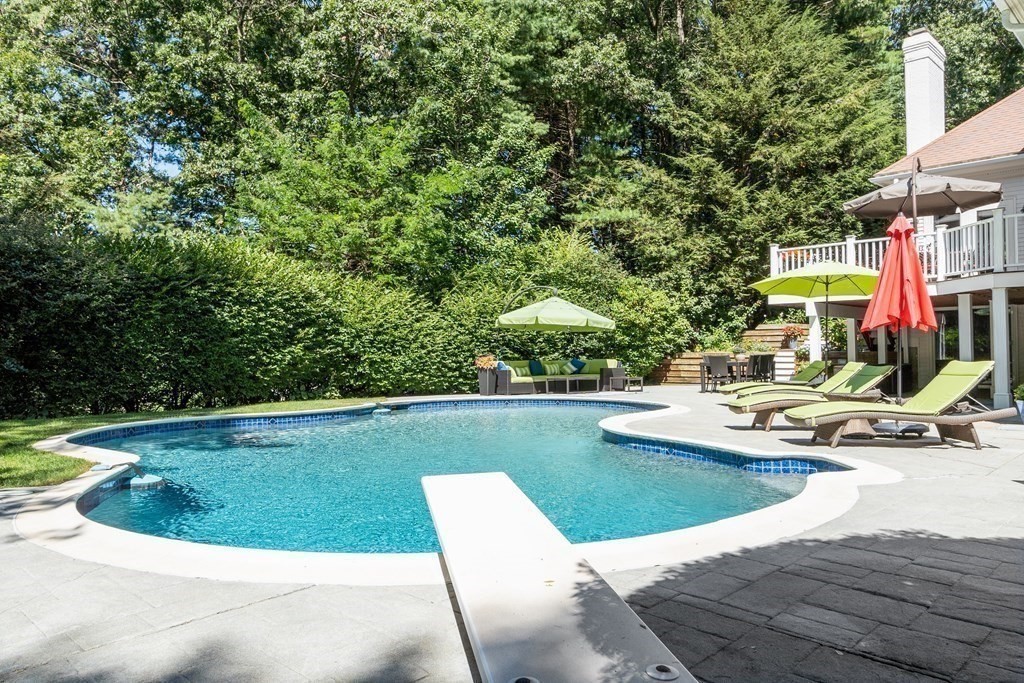 110 Mattison Drive Concord, MA 01742 - Photo 39 of 41 a view of a swimming pool with lawn chairs under an umbrella