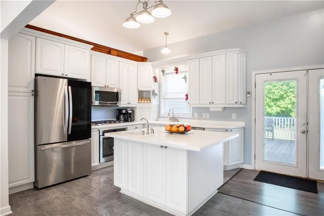 a kitchen with white cabinets and stainless steel appliances