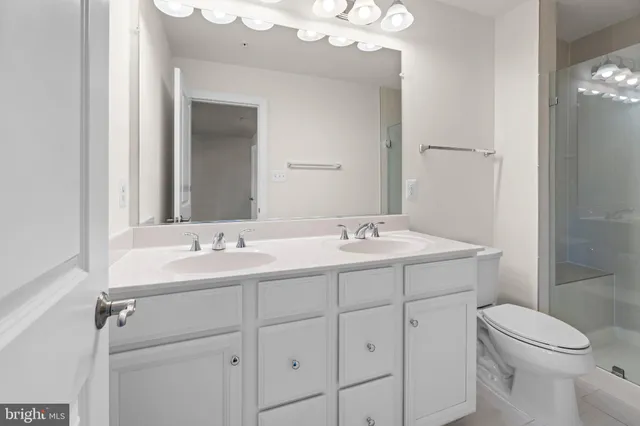 a bathroom with a toilet a sink a mirror and vanity