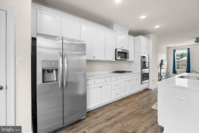 a kitchen with stainless steel appliances cabinets a sink and a refrigerator