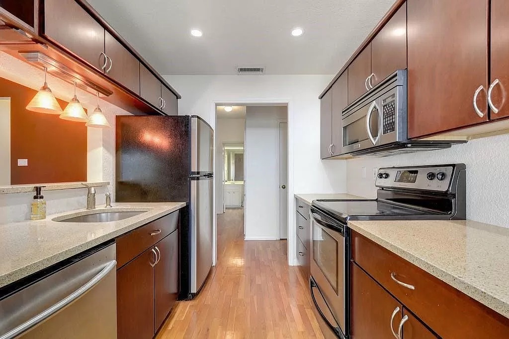 a kitchen with stainless steel appliances granite countertop a sink and a stove