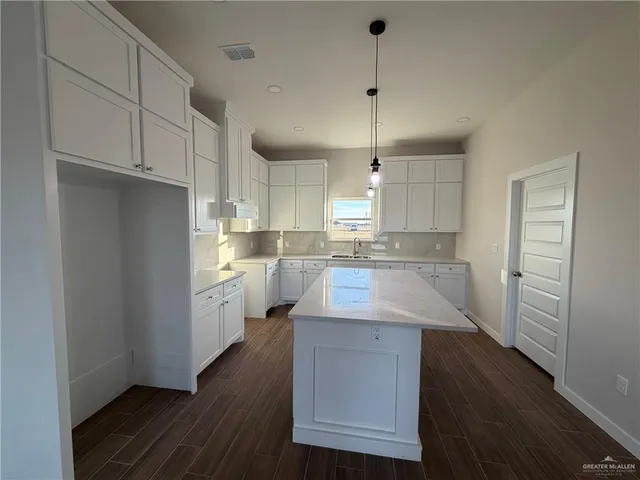 a kitchen with cabinets and wooden floor