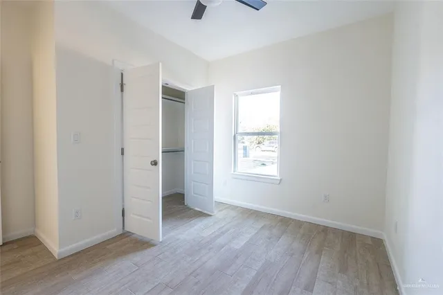 an empty room with wooden floor and window