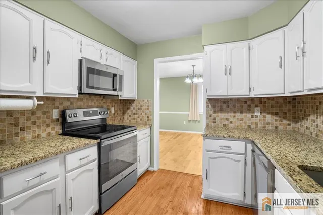 a kitchen with granite countertop a stove top oven sink and cabinets