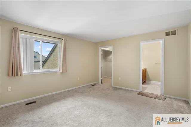 an empty room with windows and closet