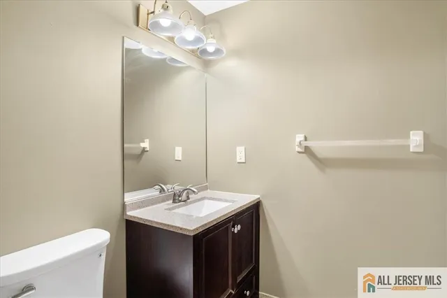 a bathroom with a sink a toilet and a mirror