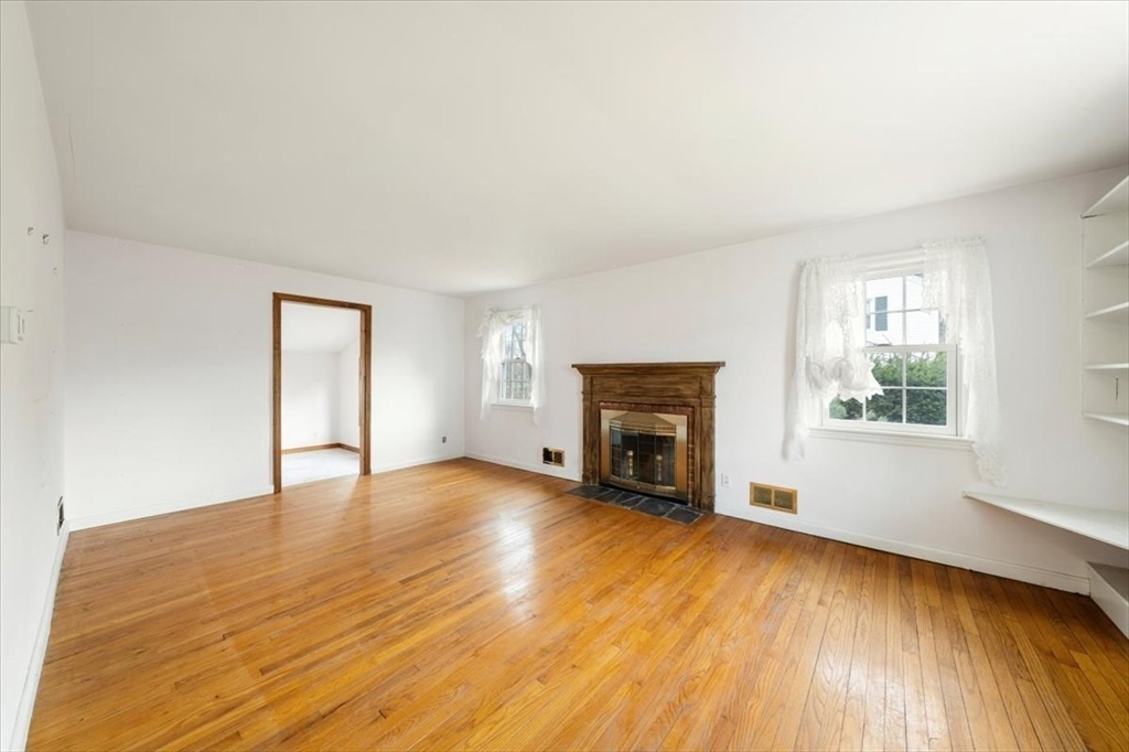 28 Barnesdale Road Natick, MA 01760 - Photo 18 of 33 an empty room with wooden floor fireplace and windows