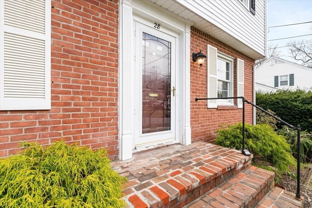 28 Barnesdale Road Natick, MA 01760 - Photo 32 of 33 a view of a brick house with a large windows and flower plants