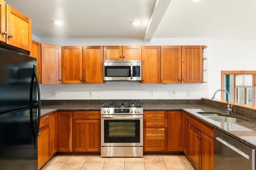 28 Barnesdale Road Natick, MA 01760 - Photo 7 of 33 a kitchen with granite countertop a sink stainless steel appliances and cabinets