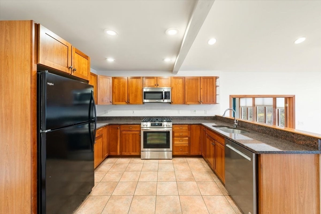 28 Barnesdale Road Natick, MA 01760 - Photo 9 of 33 a kitchen with stainless steel appliances granite countertop a stove a sink and a refrigerator
