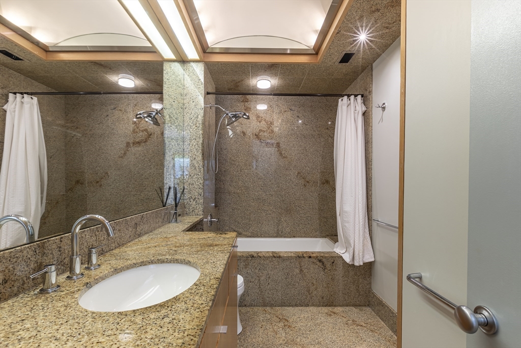 33 Bay State Road, Unit 3 Boston, MA 02215 - Photo 14 of 25 a bathroom with a granite countertop shower sink and mirror