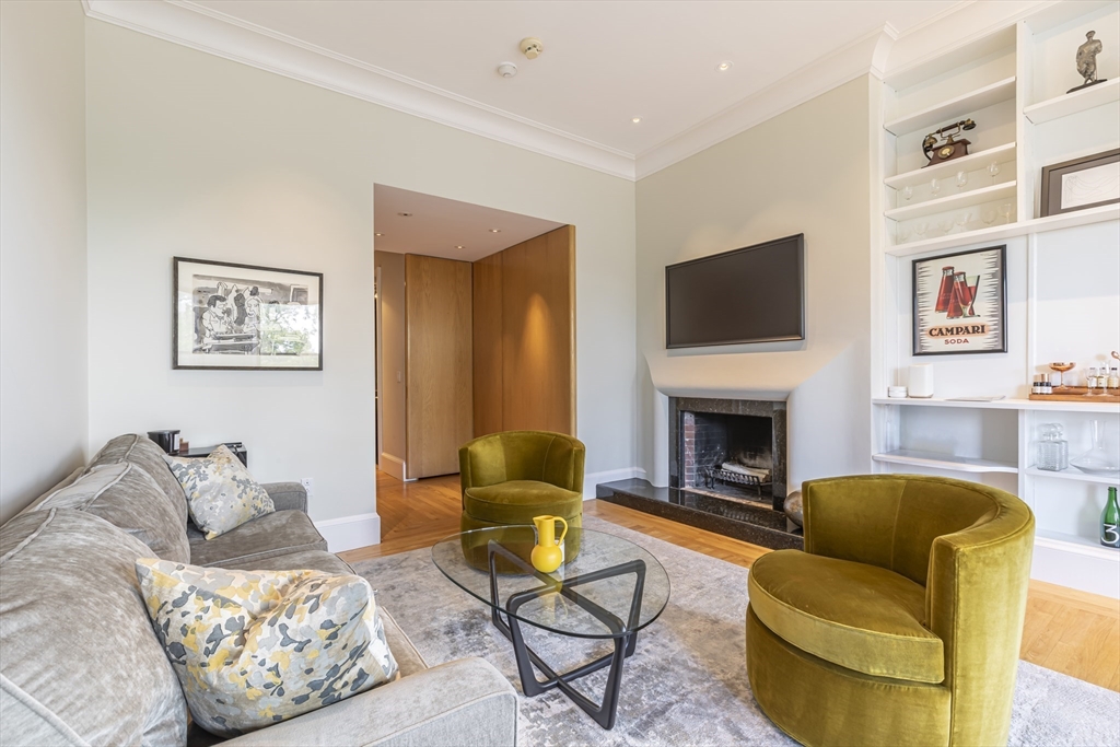 33 Bay State Road, Unit 3 Boston, MA 02215 - Photo 2 of 25 a living room with furniture a flat screen tv and a fireplace