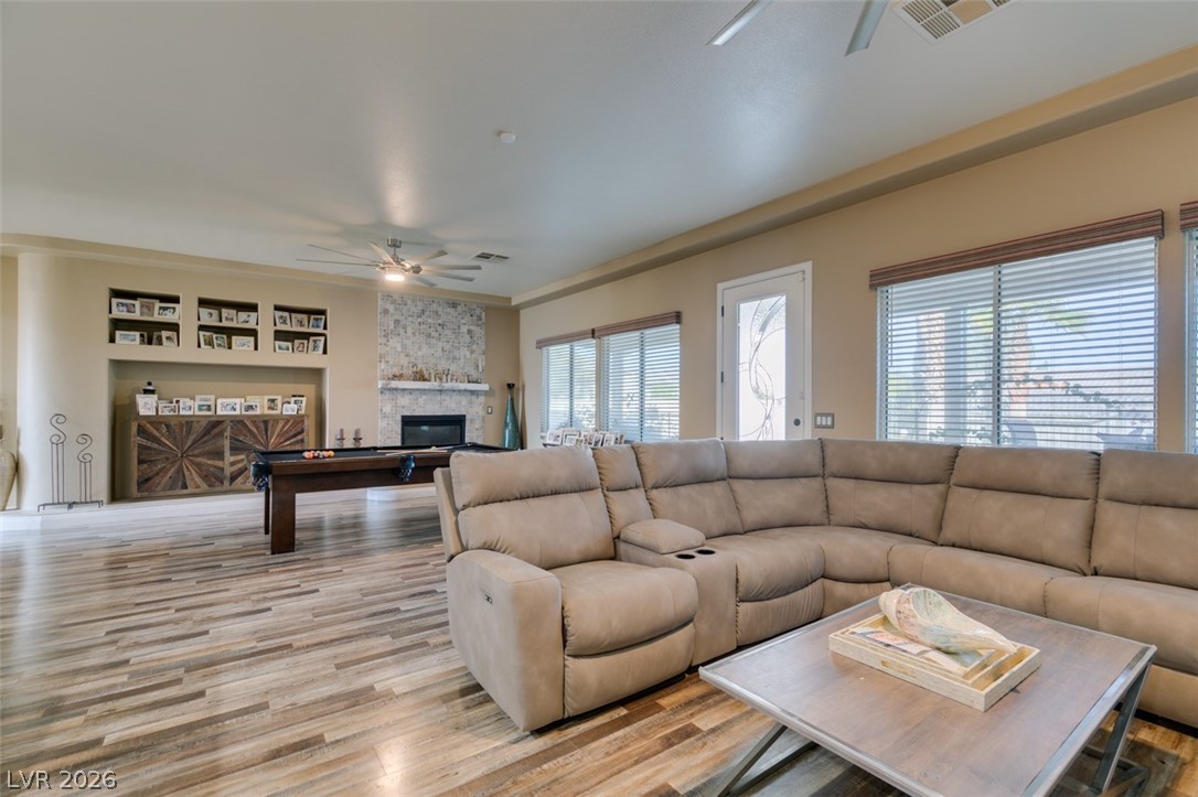 7524 Midnight Rambler Street Las Vegas, NV 89149 - Photo 16 of 51 A spacious living area featuring plank flooring and a cozy fireplace, ideal for relaxation and entertaining.