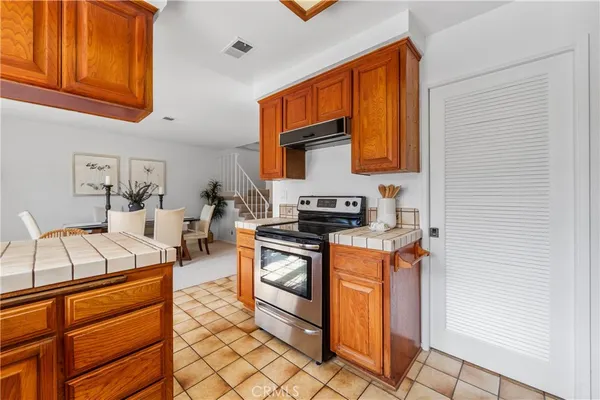 a kitchen with stainless steel appliances granite countertop a stove a sink and a refrigerator