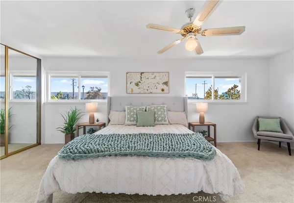 a bedroom with a large bed couch and a window