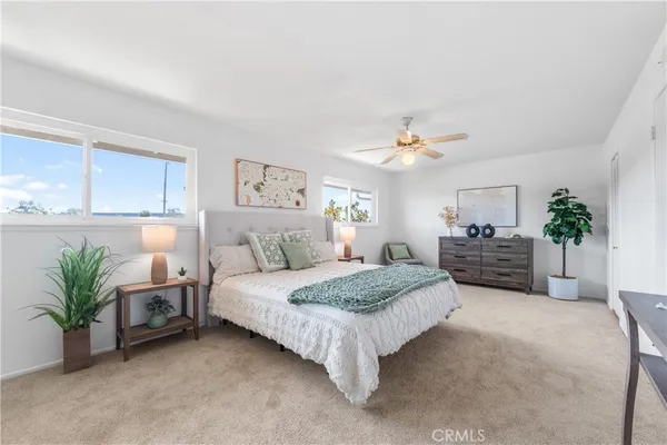 a spacious bedroom with a bed a chandelier and a couch