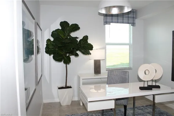 a view of a workspace with furniture and a window