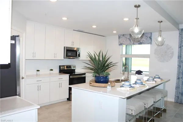 a kitchen with kitchen island white cabinets and white appliances