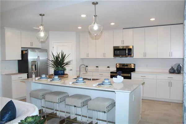 a kitchen with a sink a microwave a stove and refrigerator