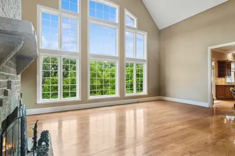 a view of an empty room with window and fire place
