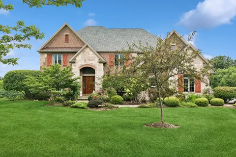 a front view of a house with a yard and trees