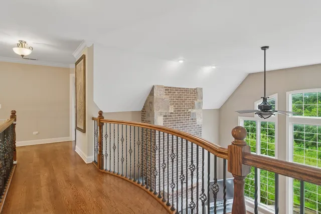 a view of a hallway with wooden floor and chandelier