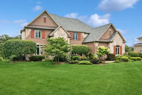 a front view of a house with a garden and plants