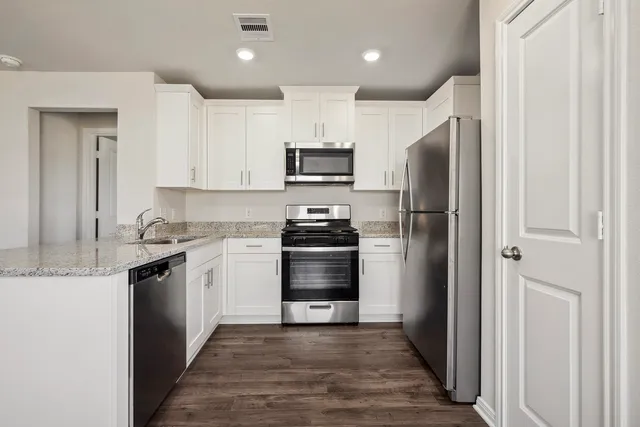 a kitchen with granite countertop a refrigerator and a stove