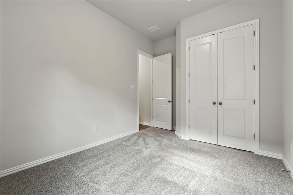 921 Alberta Spruce Road Justin, TX 76247 - Photo 20 of 24 Unfurnished bedroom with light colored carpet and a closet