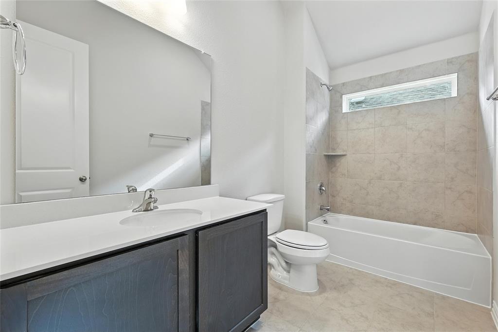 921 Alberta Spruce Road Justin, TX 76247 - Photo 21 of 24 Bathroom with vanity, shower combination, and vaulted ceiling