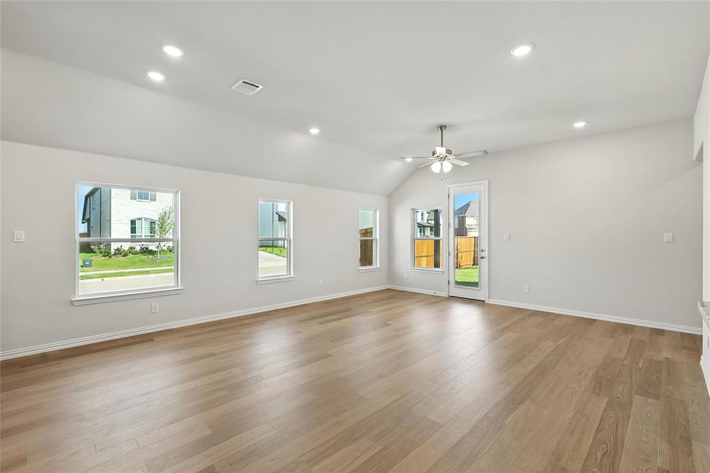 921 Alberta Spruce Road Justin, TX 76247 - Photo 7 of 24 Unfurnished room with a ceiling fan, light wood-type flooring, vaulted ceiling, plenty of natural light, and recessed lighting