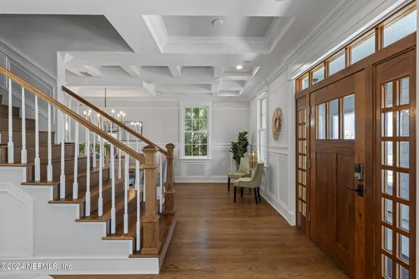 a view of a dining room with furniture a chandelier and wooden floor