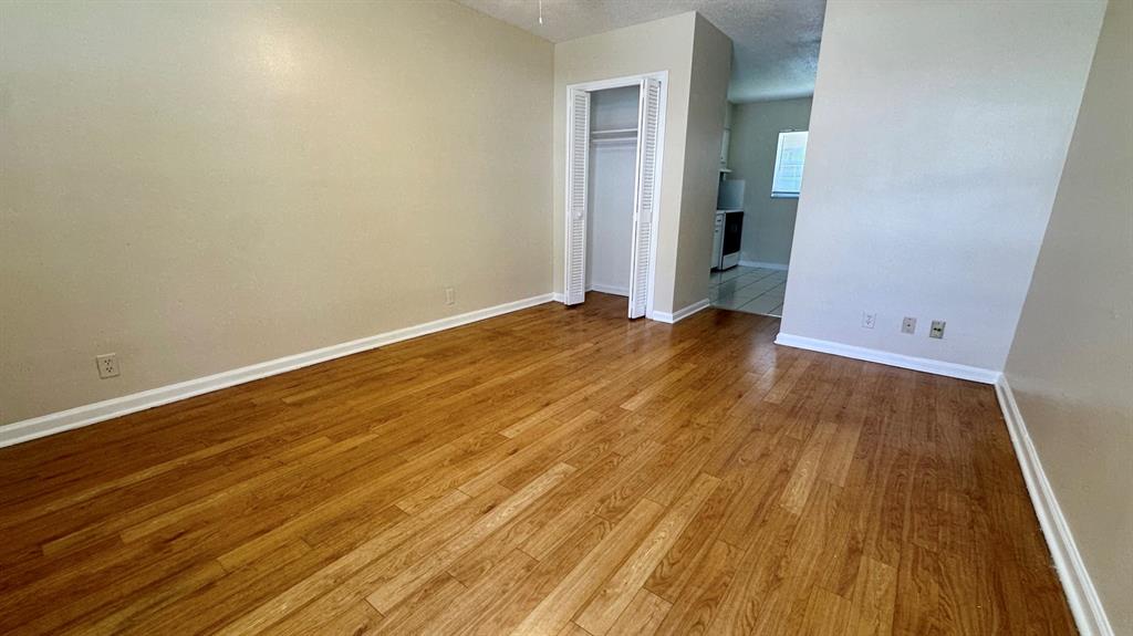 1973 Northeast 4th Street, Unit 2 Deerfield Beach, FL 33441 - Photo 3 of 7 an empty room with wooden floor and entrance