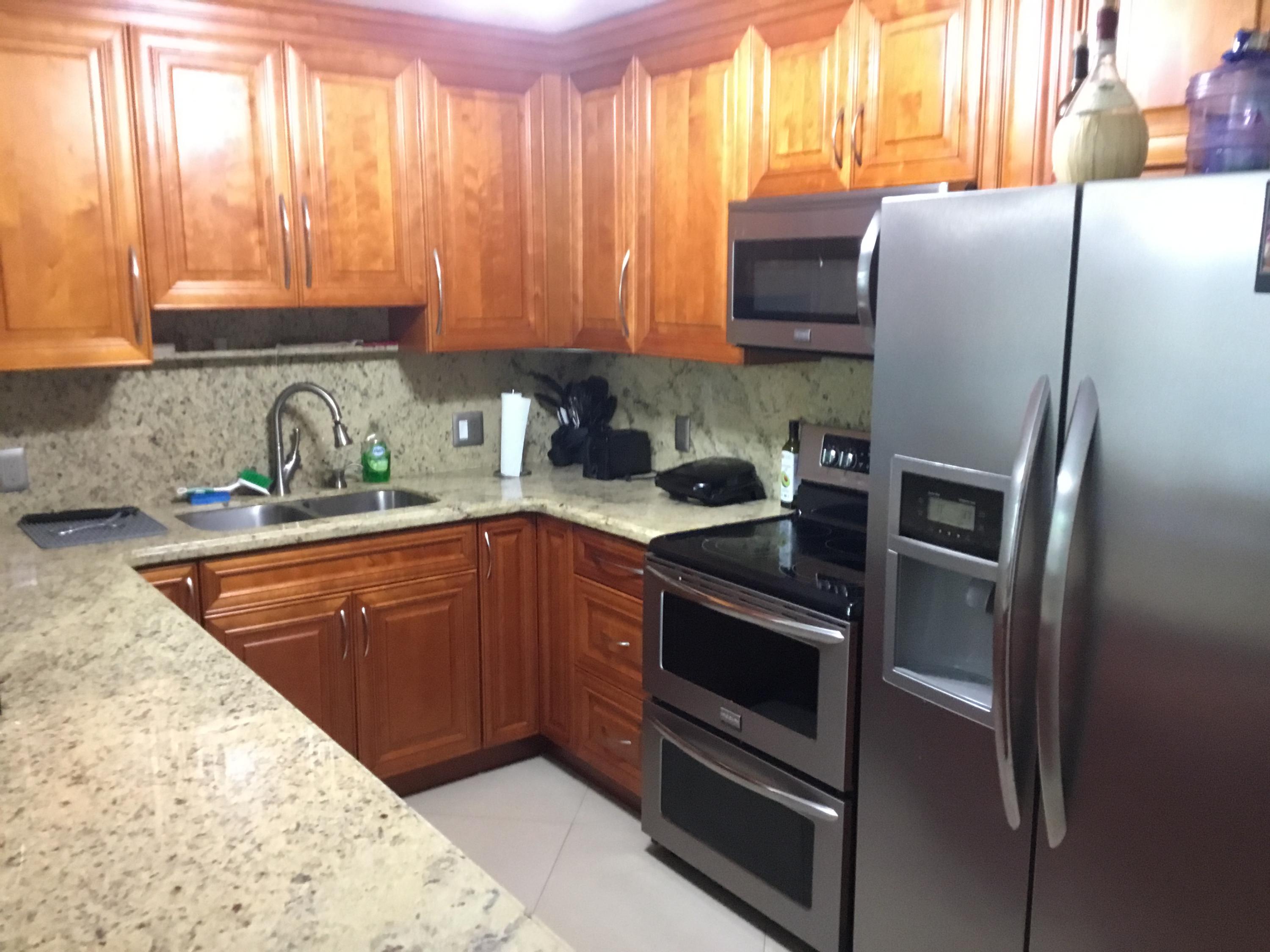 906 Southwest 9th St Circle, Unit 106 Boca Raton, FL 33486 - Photo 5 of 26 a kitchen with stainless steel appliances granite countertop a refrigerator sink and stove