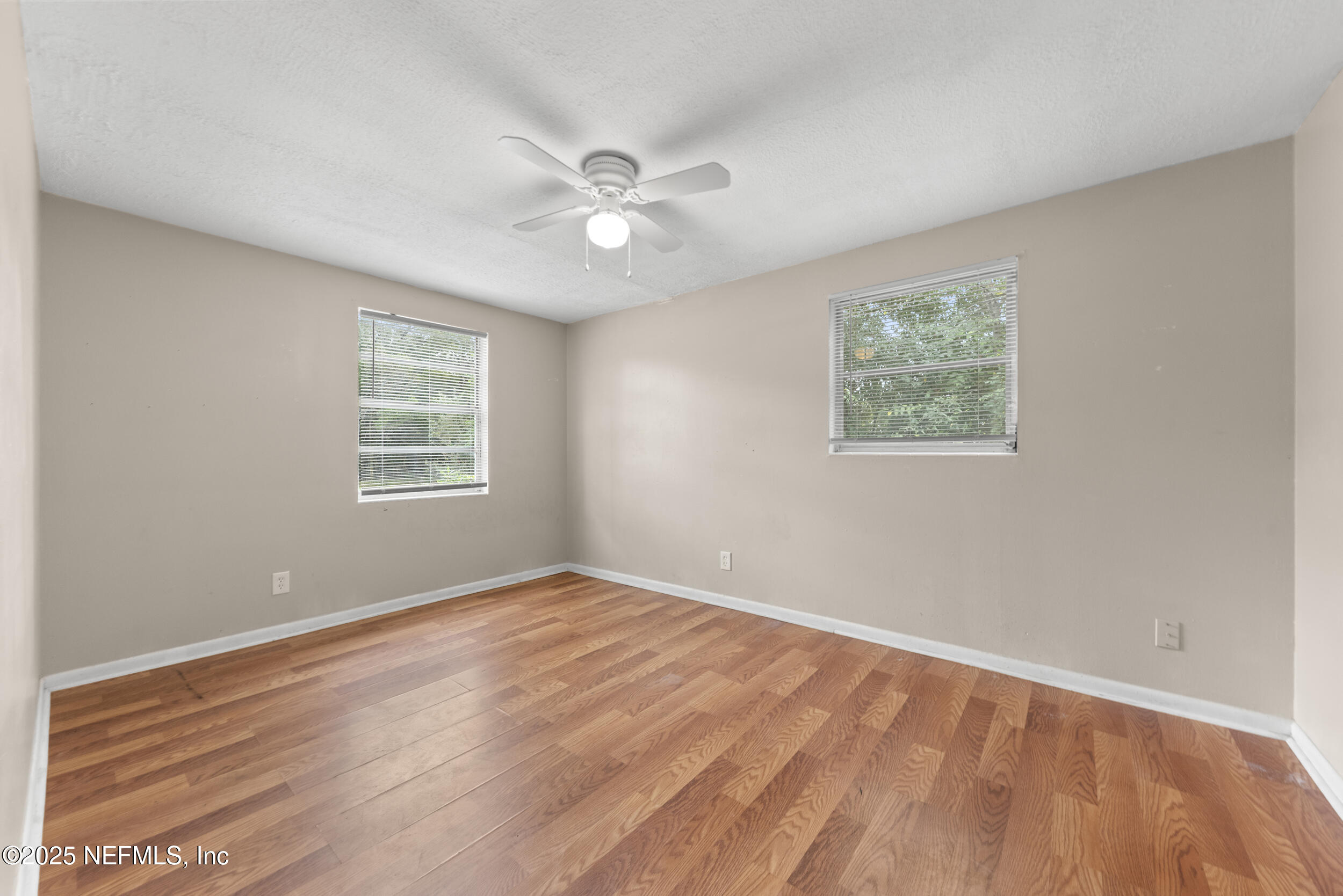 5646 Ricker Road Jacksonville, FL 32244 - Photo 16 of 27 a view of an empty room with wooden floor and a window