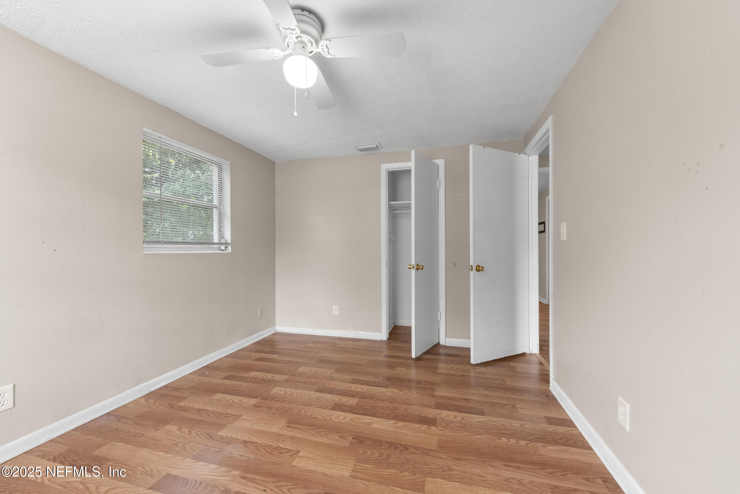 5646 Ricker Road Jacksonville, FL 32244 - Photo 17 of 27 wooden floor in an empty room with a window