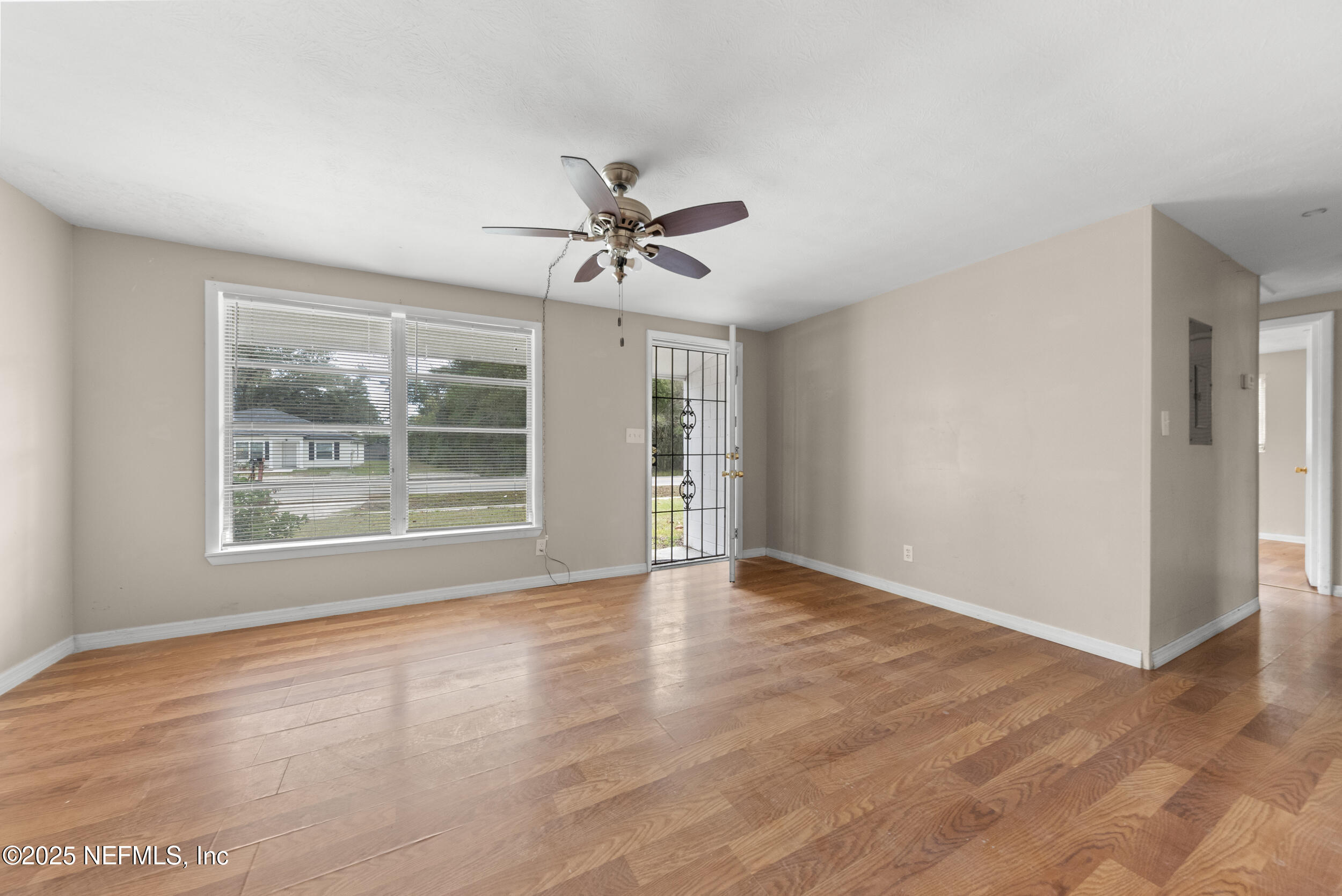 5646 Ricker Road Jacksonville, FL 32244 - Photo 5 of 27 a view of an empty room with a window and wooden floor