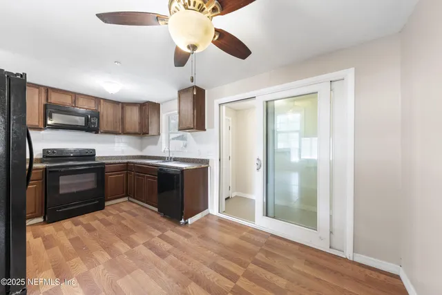 a kitchen with stainless steel appliances granite countertop a refrigerator a stove a sink and a microwave