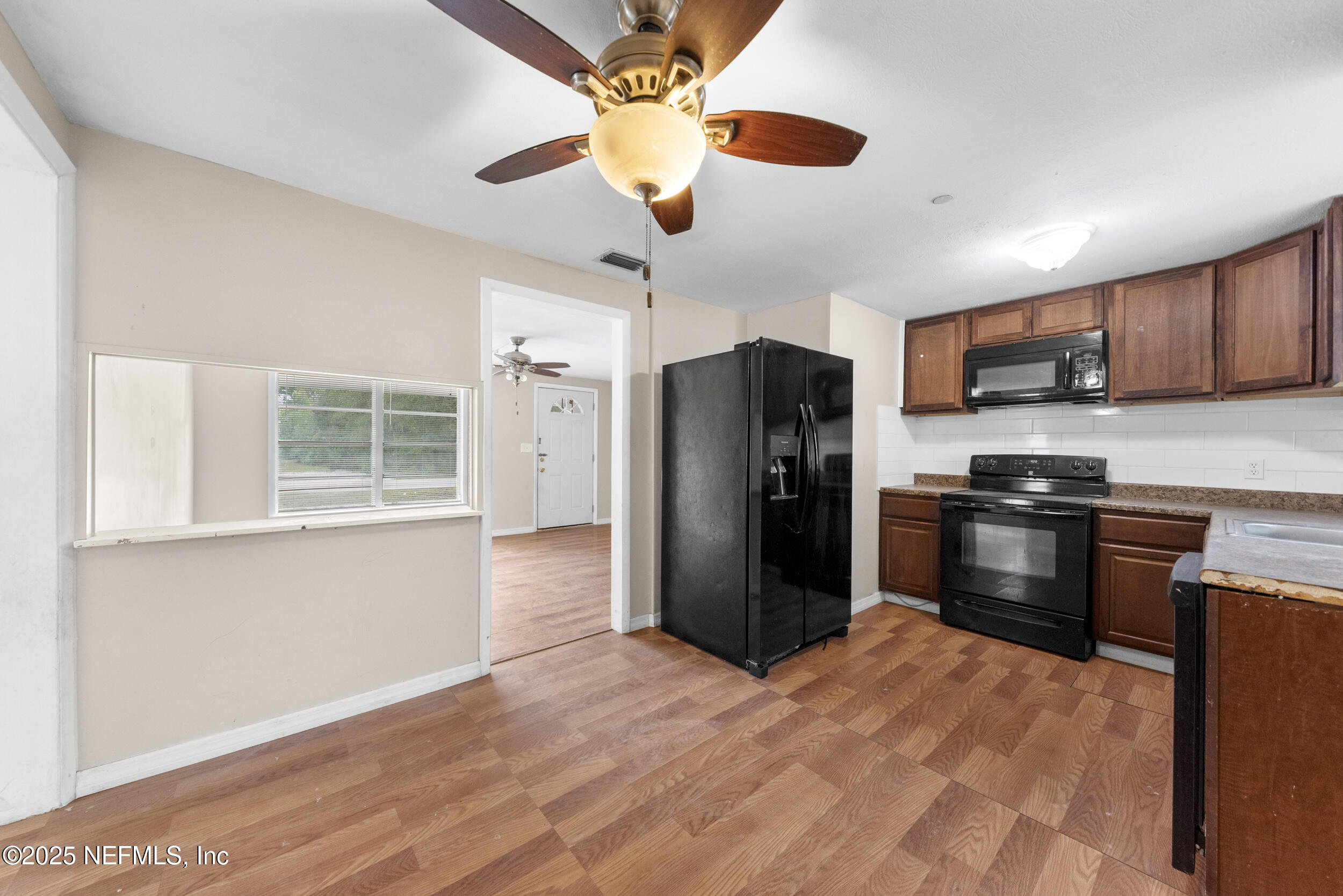 5646 Ricker Road Jacksonville, FL 32244 - Photo 9 of 27 a kitchen with stainless steel appliances kitchen island granite countertop a refrigerator and a stove top oven