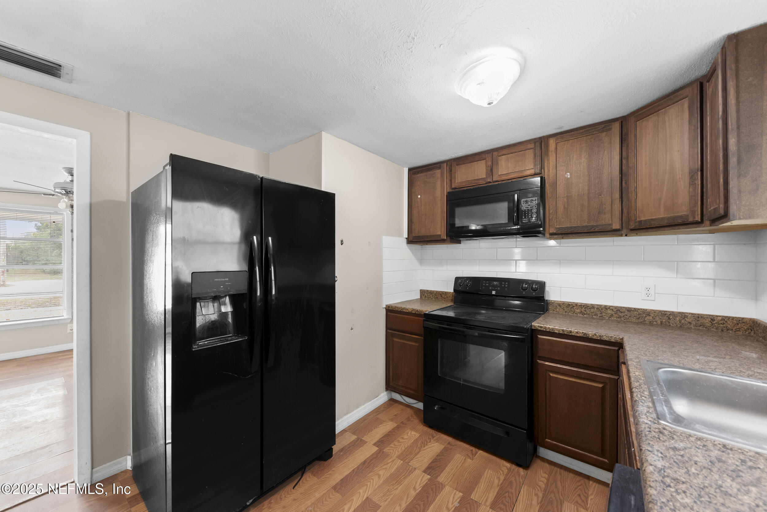 5646 Ricker Road Jacksonville, FL 32244 - Photo 10 of 27 a kitchen with a refrigerator stove and microwave