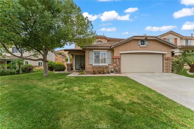 a front view of a house with a yard and trees